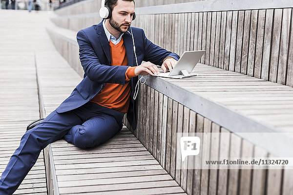 USA  New York City  Businessman sitting on stairs using digital tablet