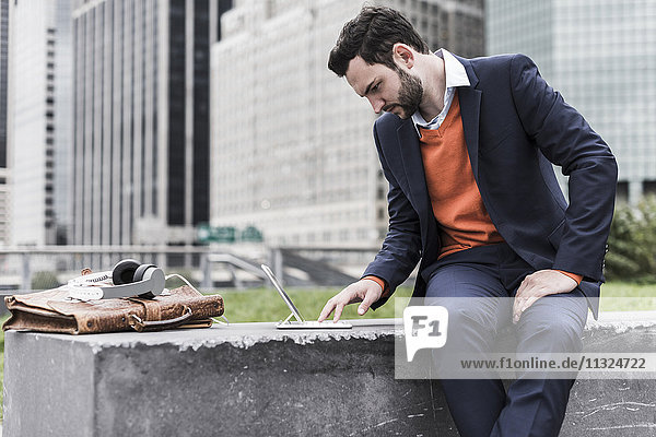 USA  New York City  Businessman working outdoor sitting on bench