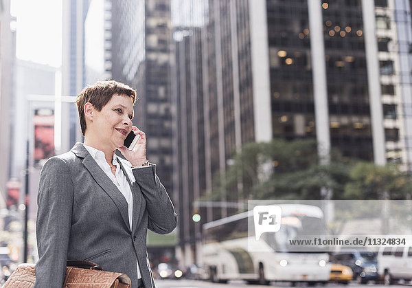USA  New York City  Geschäftsfrau in Manhattan im Gespräch am Handy