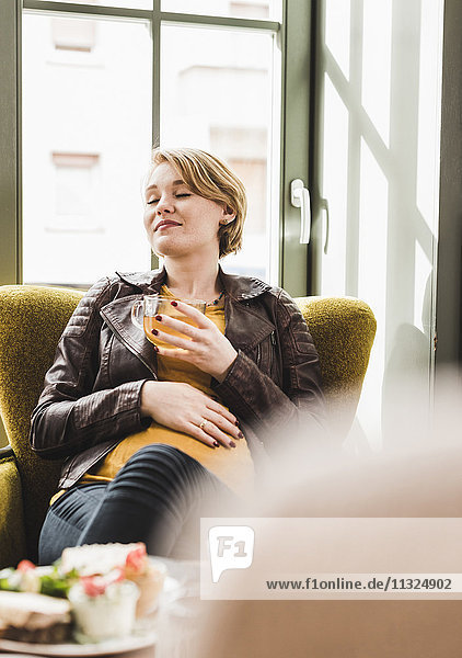 Pregnant young woman relaxing in a cafe