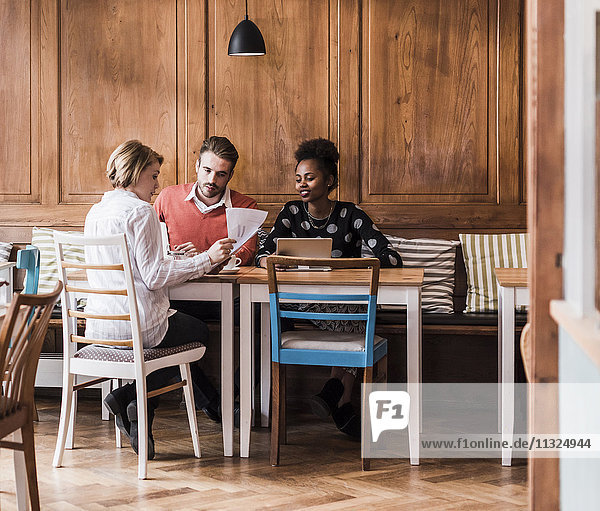 Drei junge Leute bei einem Treffen in einem Café