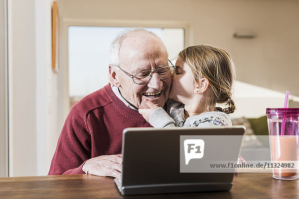 Großvater und Enkelin nutzen gemeinsam den Laptop