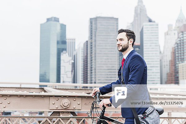 USA  New York City  businessman with bicycle on Brooklyn Bridge