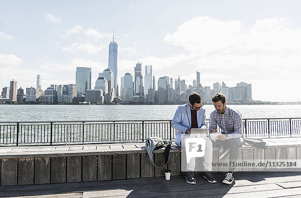 USA  zwei Geschäftsleute  die an der Waterfront von New Jersey mit Blick auf Manhattan arbeiten.