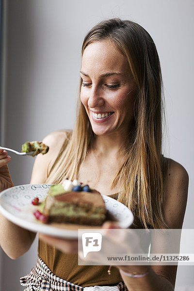 Frau isst veganen Matcha-Kuchen