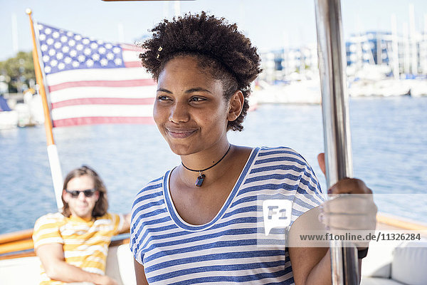 Lächelnde junge Frau auf einer Bootsfahrt