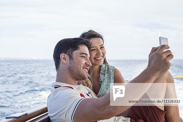 Glückliches Paar auf einer Bootsfahrt mit einem Selfie