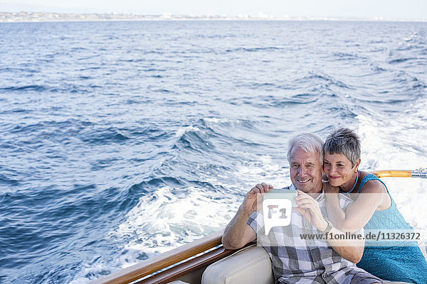 Lächelndes Paar auf einer Bootsfahrt mit einem Selfie