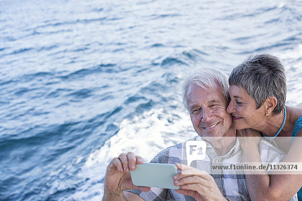 Glückliches Paar auf einer Bootsfahrt mit einem Selfie