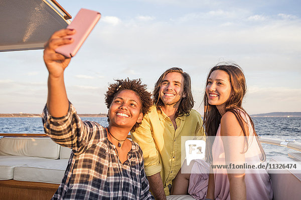 Freunde auf einer Bootsfahrt mit einem Selfie