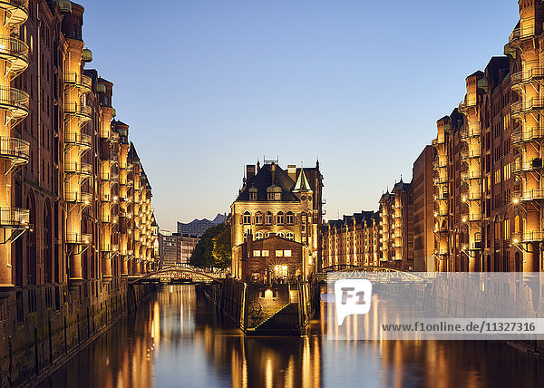 Deutschland  Hamburg  Speicherstadt  beleuchtete Altbauten mit Elbphilharmonie im Hintergrund
