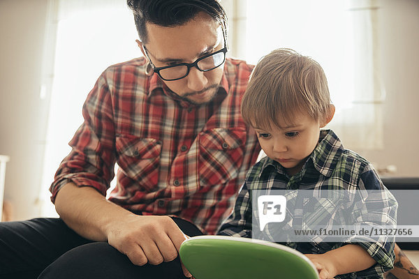 Vater und Sohn mit Spielzeug-Laptop