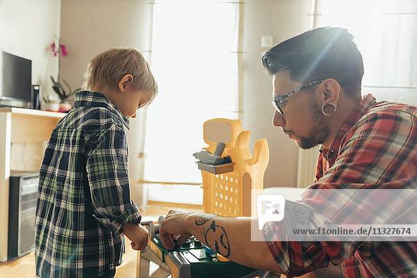 Vater und Sohn spielen zusammen auf der Spielzeugwerkbank