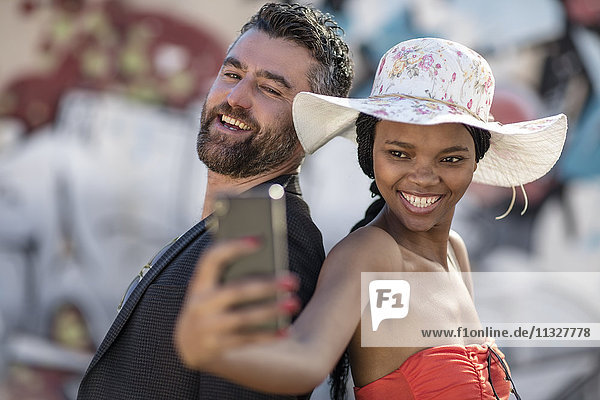 Lächelnder Mann und Frau  die einen Selfie mit Handy nehmen