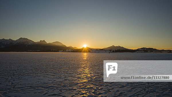 ice covered Hopfensee lake at sunset