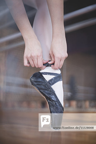 Balletttänzerin beim Anziehen von Schuhen