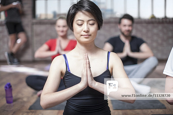Junge Frau beim Yoga-Meditationstraining im Studio