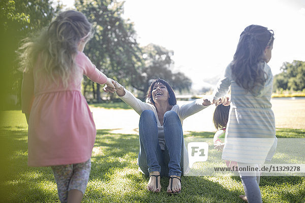 Zwei Mädchen  die mit ihrer Mutter im Park spielen.