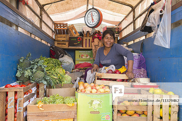 Frau verkauft Gemüse aus einem Lastwagen in Peru