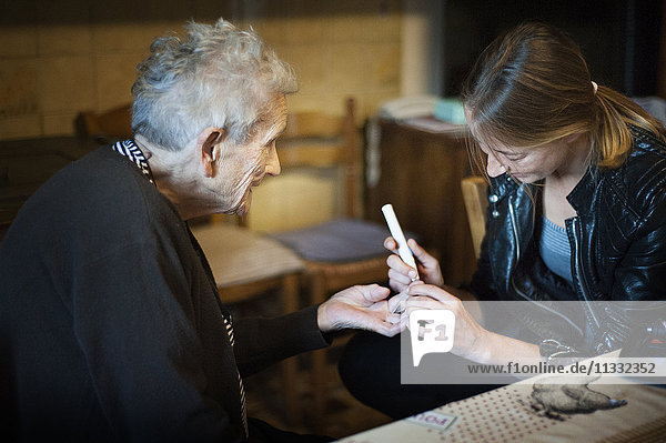 Reportage über eine selbstständige Krankenschwester in Haute-Savoie  Frankreich. Aline ist jeden Tag in ihrem kleinen Bergdorf unterwegs  um ihre Patienten zu besuchen. Sie hat auch eine Praxis in der Stadt  die sie sich mit zwei anderen Kollegen teilt. Aline testet den Blutzuckerspiegel eines Patienten.