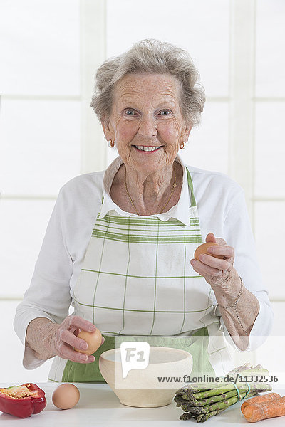 Ältere Frau beim Kochen.