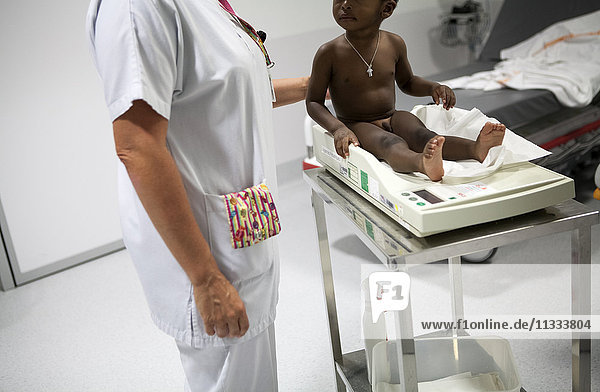 Reportage aus der pädiatrischen Notaufnahme eines Krankenhauses in Haute-Savoie  Frankreich. Eine Hilfskrankenschwester wiegt ein Baby.