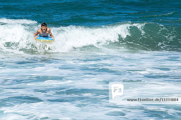 Ein Junge surft auf den Wellen