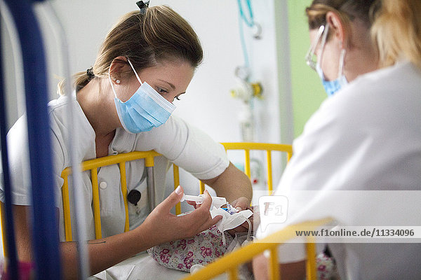 Reportage aus der Kinderabteilung eines Krankenhauses in Haute-Savoie  Frankreich. Zwei Krankenschwestern geben einem Baby Medikamente.