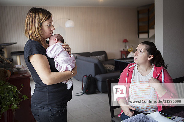 Reportage über eine freiberufliche Hebamme bei Hausbesuchen nach der Entbindung. Die Hebamme berät eine junge Mutter.