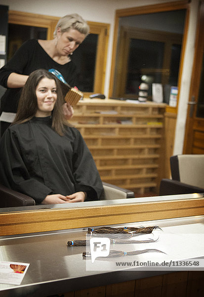 A 17-year old girl donates hair at her hairdressers  a Solidhair charity partner. The haidresser takes 24 cm of hair that will be sent to the French charity. The hair will then be sold to wigmakers. The money generated will subsidise capillary prostheses for underprivileged cancer sufferers.
