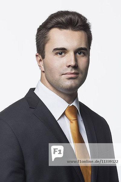 Porträt eines selbstbewussten  gut gekleideten Geschäftsmannes vor weißem Hintergrund