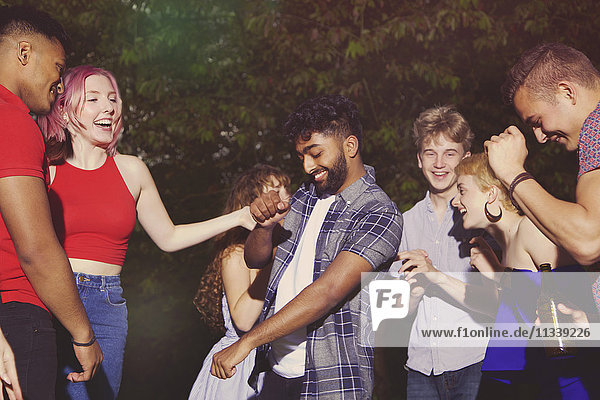 Fröhliche multiethnische Freunde  die während der Party auf dem Hof tanzen.