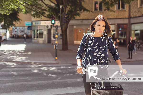 Geschäftsfrau beim Radfahren auf der Stadtstraße