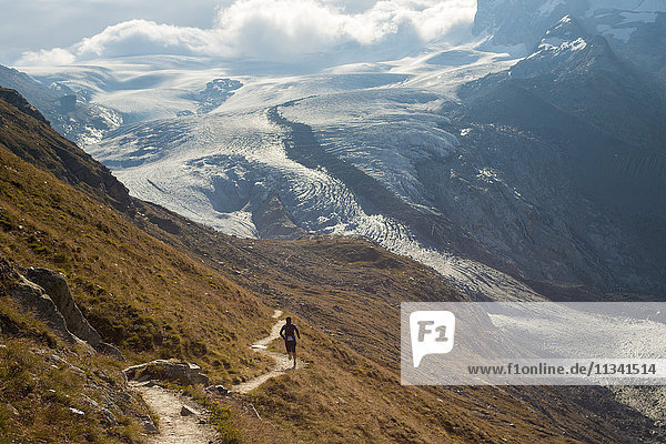 Laufen in den Schweizer Alpen bei Zermatt mit Blick auf den Monte Rosa in der Ferne  Zermatt  Wallis  Schweiz  Europa