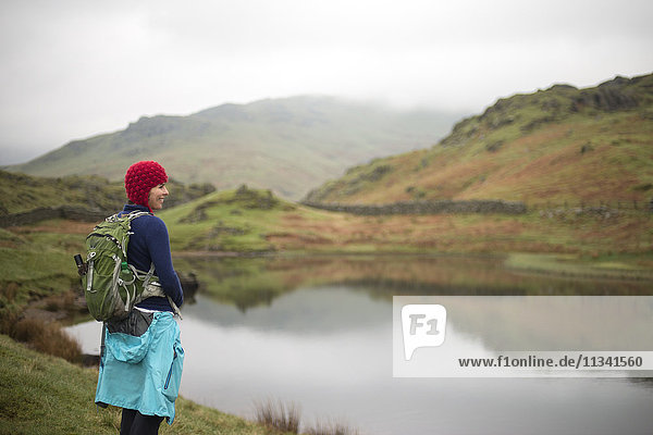 A woman looks out over Alcock Tarn near Grasmere  Lake District National Park  Cumbria  England  United Kingdom  Europe