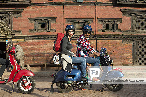 Ein Tourist auf einem Motorroller vor einem Newari-Gebäude in Patan in Kathmandu  Nepal  Asien