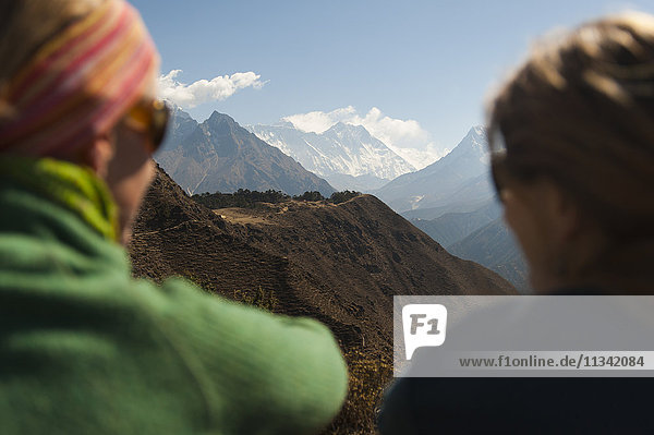 Zwei Trekker erhaschen ihren ersten Blick auf den Everest vom Everest View Hotel in der Nähe von Khumjung  Khumbu-Region  Himalaya  Nepal  Asien