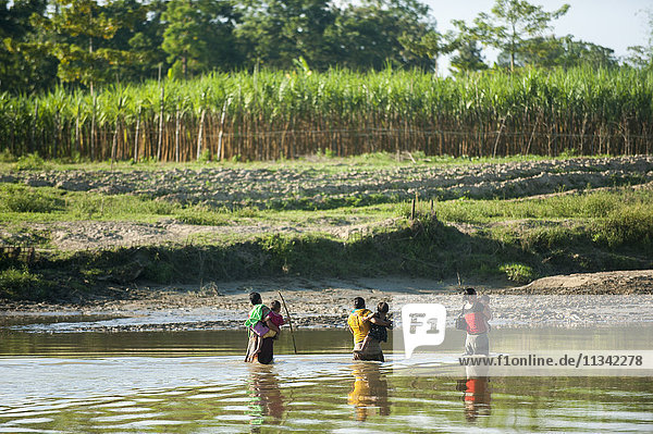 Women cross a river carrying their children in their arms  Chittagong Hill Tracts  Bangladesh  Asia