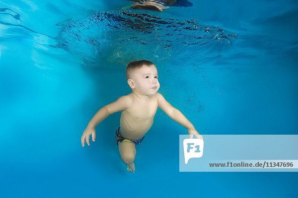 2 years boy learning to swim underwater in the pool Odessa Ukraine.