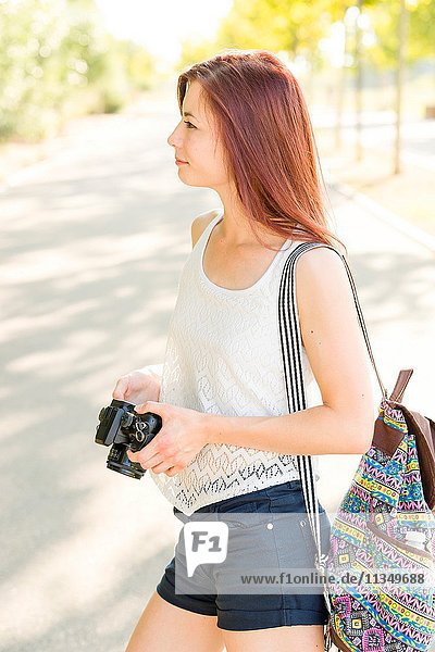 Woman photographer observes the landscape in a park.