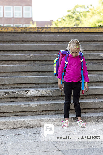 Mädchen steht mit Schulranzen an der Treppe  Kiel  Schleswig-Holstein  Deutschland  Europa