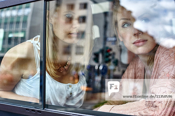 Two young women behind car window