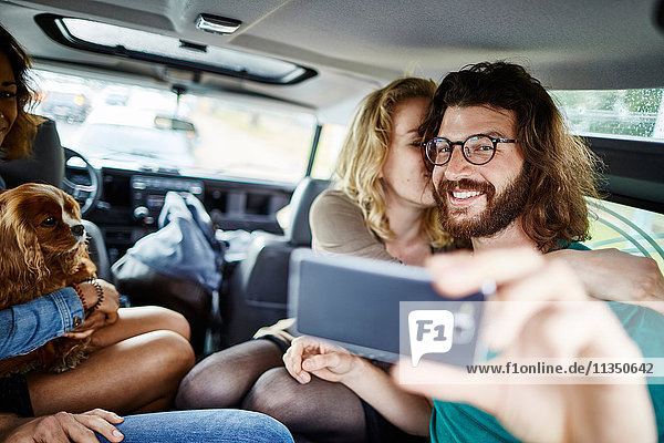 Glückliches Paar macht ein Selfie im Auto