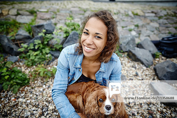 Smiling young woman with dog outdoors