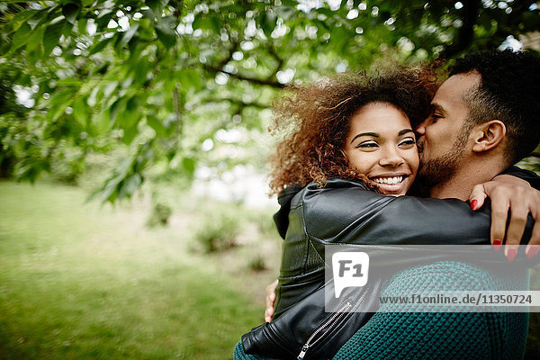 Happy young couple hugging outdoors