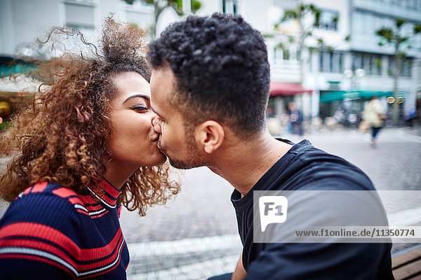 Junges Paar küsst sich in der Stadt