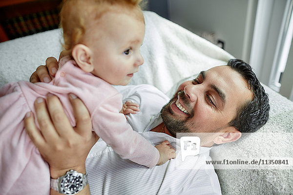 Vater und Baby liegen Zuhause