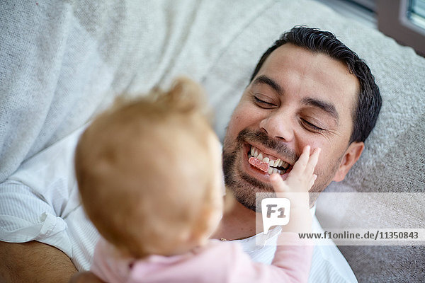 Vater und Baby liegen Zuhause