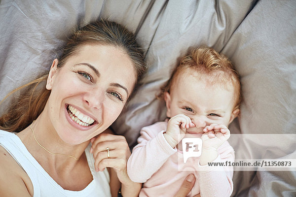 Portrait einer glücklichen Mutter und Baby im Bett