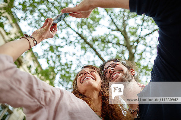 Lächelndes junges Paar macht ein Selfie im Freien